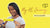 Photo showing a smiling Black woman with braids, wearing a light short-sleeved top and holding up a sachet of Absolute Collagen on a yellow background