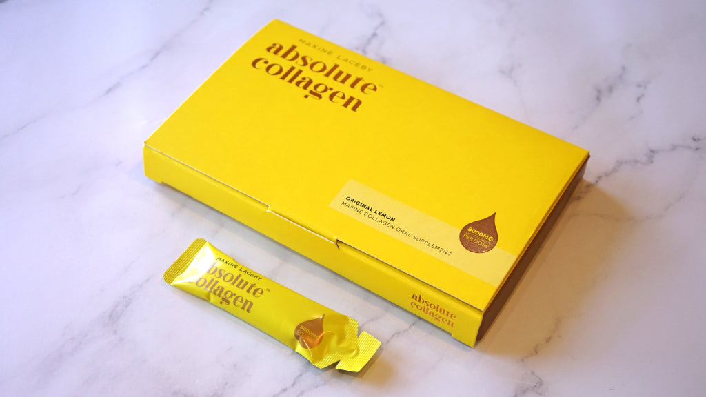 Photo showing an Absolute Collagen box and sachet resting on a white marble background