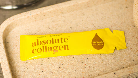 Image of yellow absolute collagen sachet laying on tray in bathroom