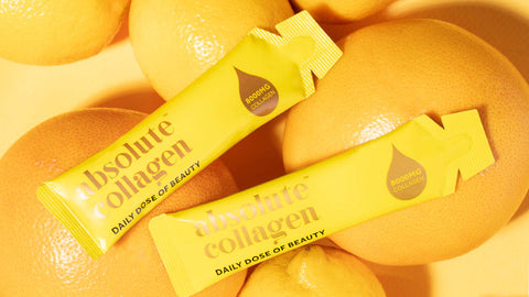 Photo of two Absolute Collagen sachets laying on some oranges