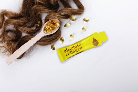 Photo of brown hair alongside a spoonful of vitamins and a yellow Absolute Collagen sachet